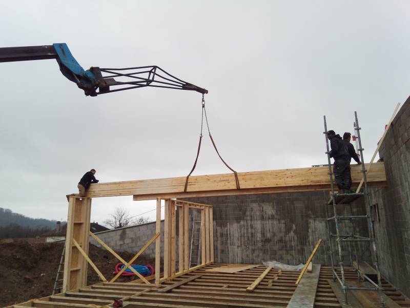 Pose d' une partie de la structure en ossature bois pour la construction d' une maison contemporaine à toit plat végétalisé sur la commune de St Savin