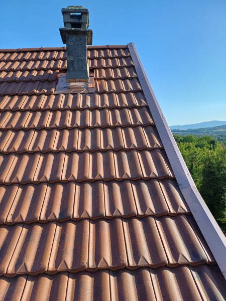 Pose d'une couverture en tuile Deltas 10 et remplacement de gouttières et rives en cuivre sur cette maison dans la commune de St Chef en région Nord Isère