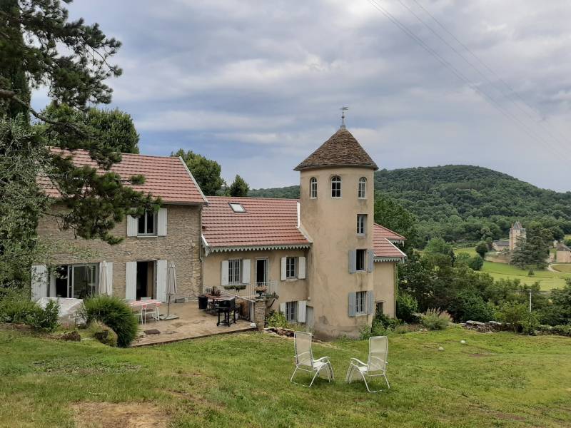 Vue de l' ensemble du batiment  recouvert d' une toiture en tuile et d'une couverture en lauze sur la tour demi rond sur la commune de Crémieu