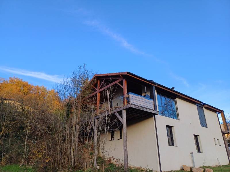 Réalisation d'un auvent en pin Douglas avec couverture en tuiles rouges Oméga 10 par la Sarl CartonLecraz se situent sur la commune de Dizimieu en région Nord Isère